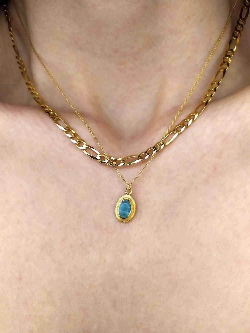 Neckline with gold jewelry. Necklace with stone.